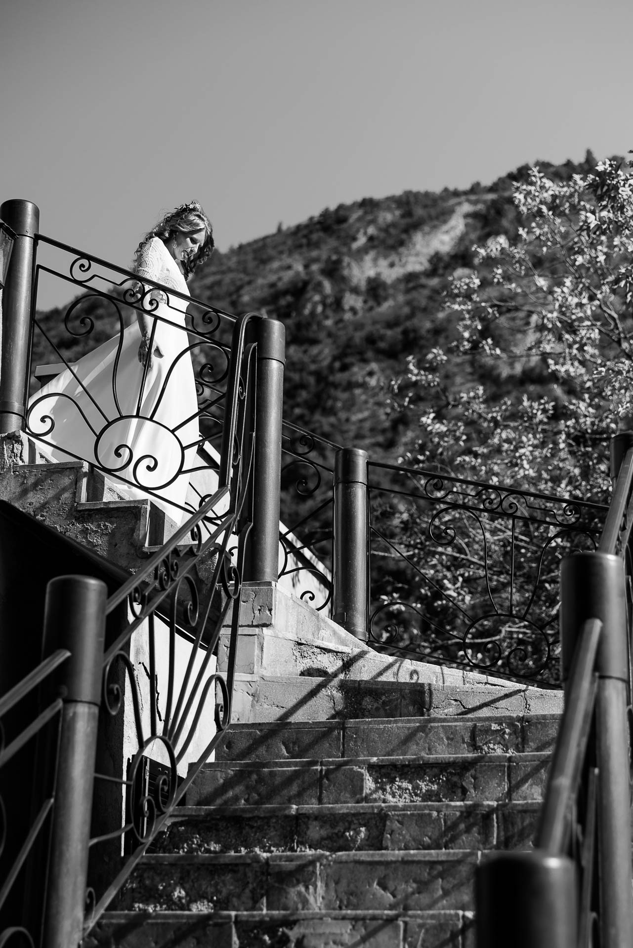 Bride walking down a wrought-iron staircase in the South of France