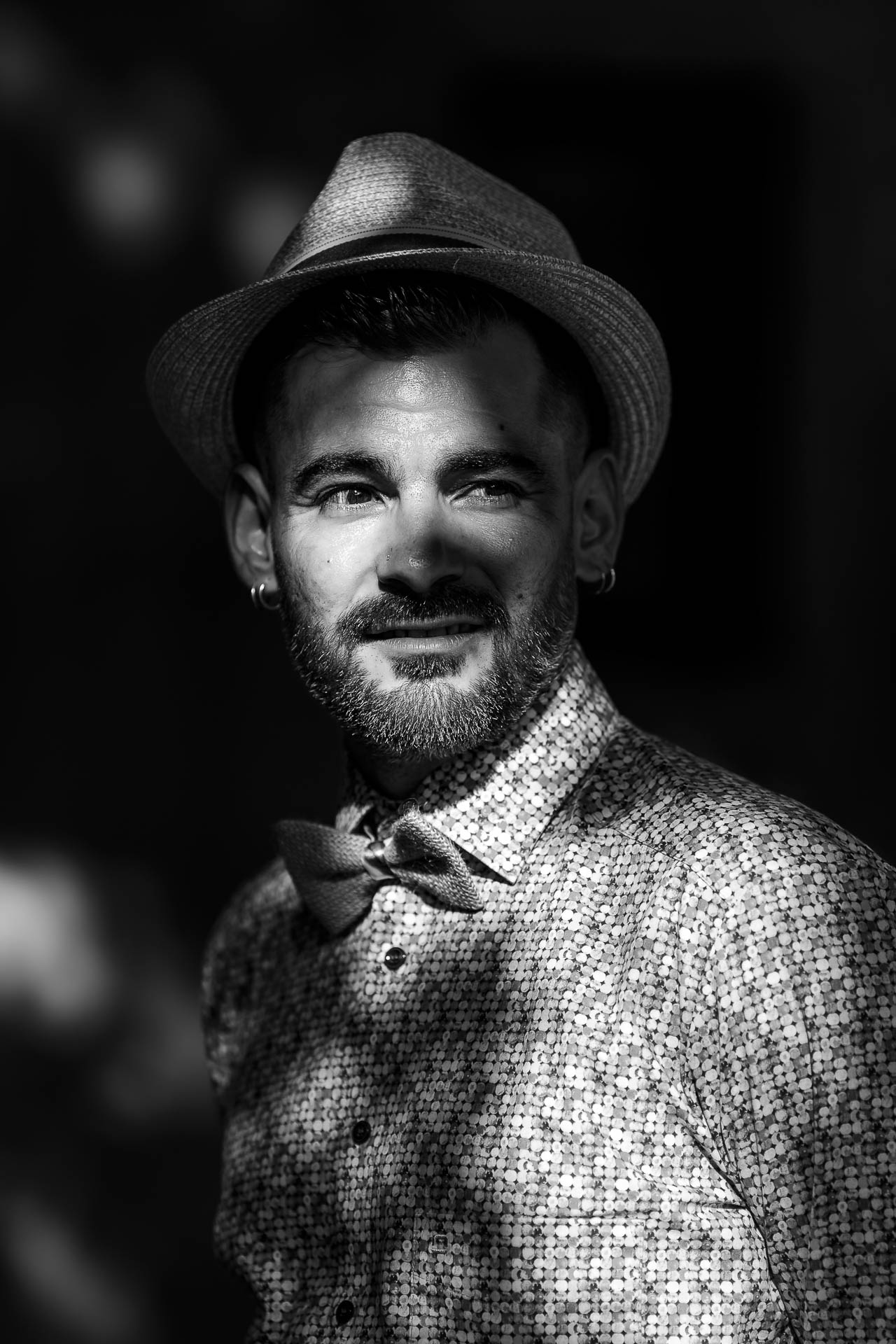 Groom portrait in hat and bow tie, dramatic light
