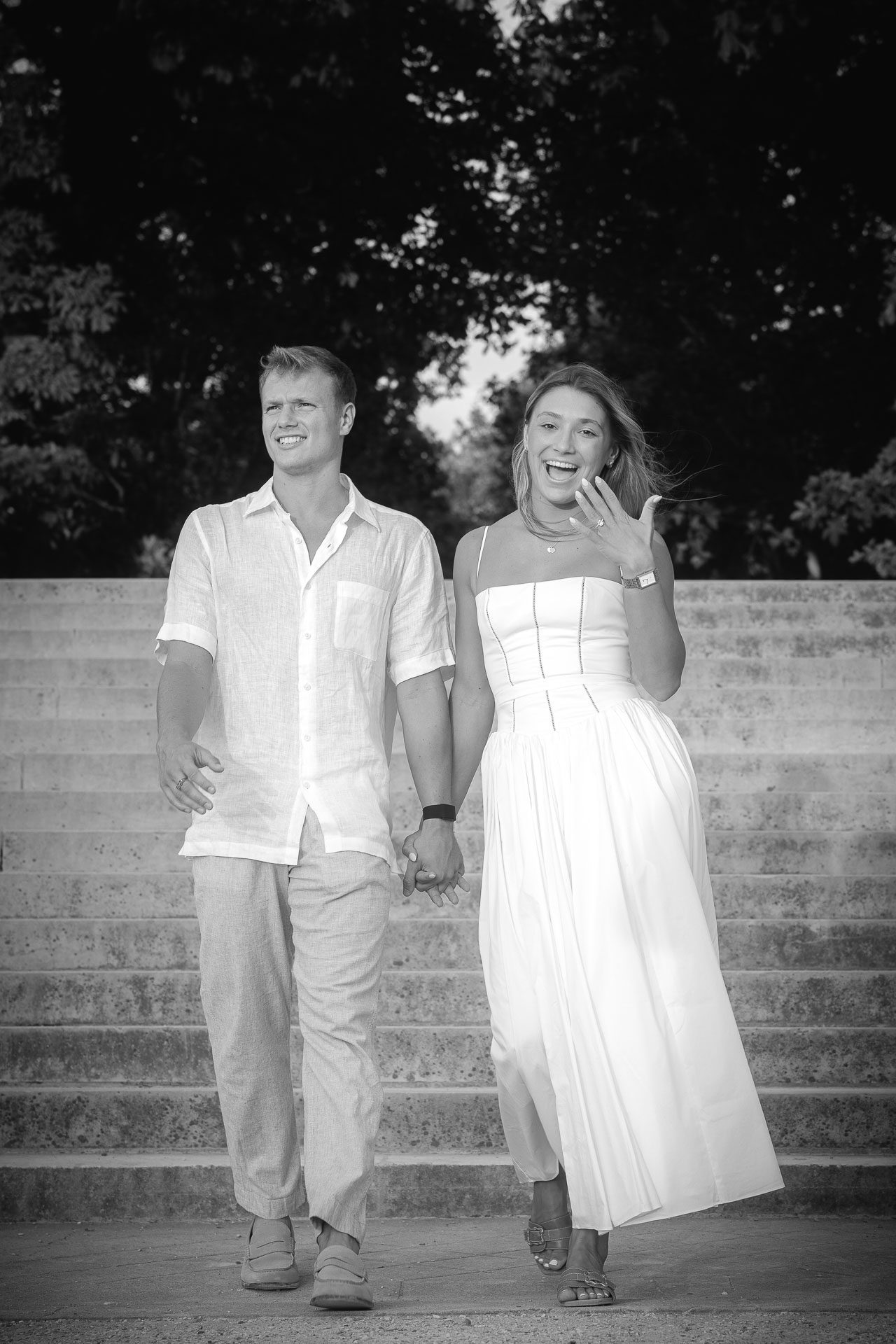 Engaged couple walking hand in hand, Maycey showing her ring