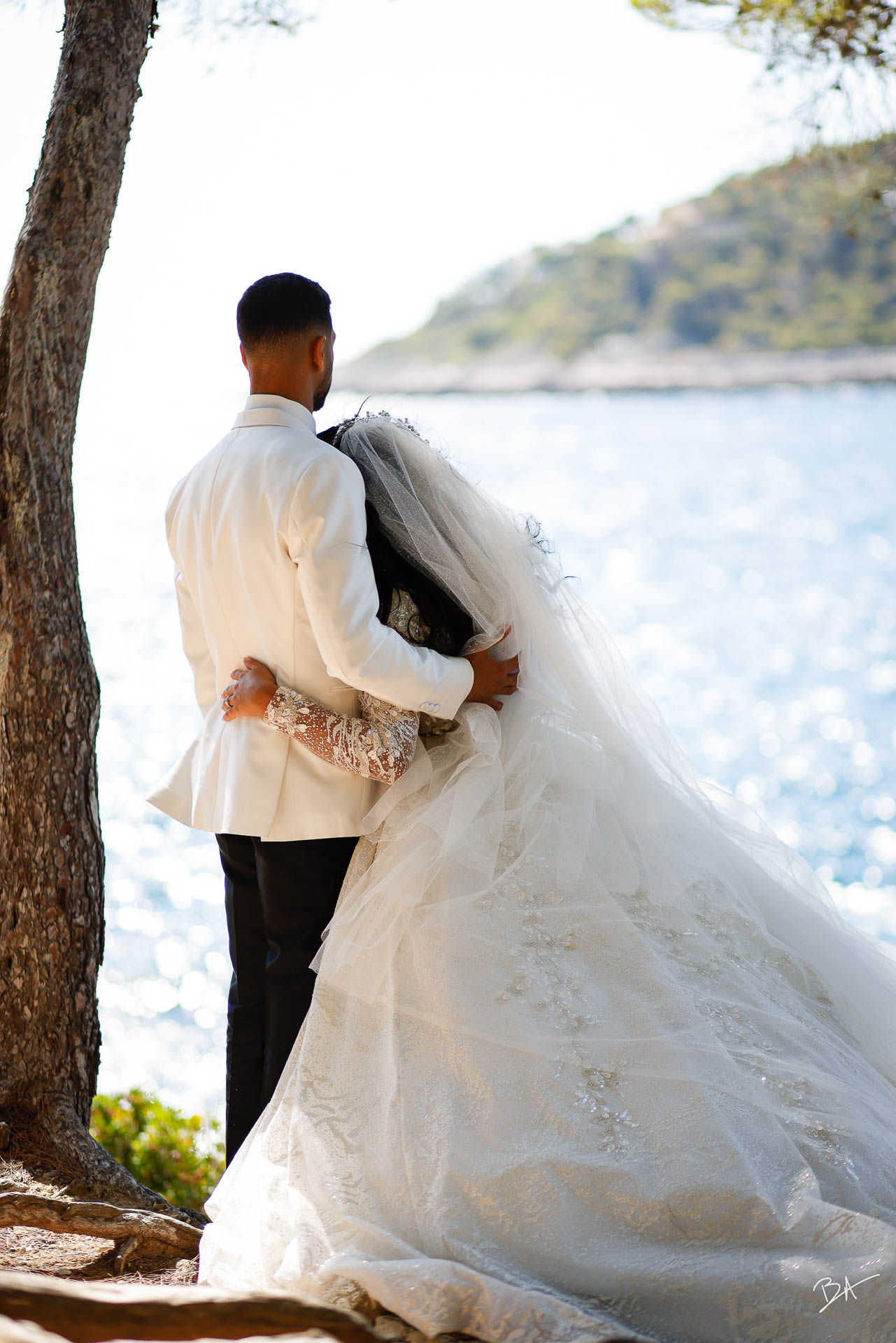 Bride and groom looking over the Mediterranean Sea